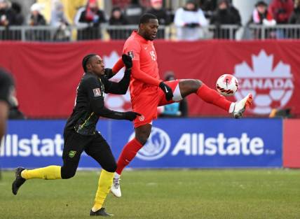 Mar 27, 2022; Toronto, Ontario, CAN;   Canada defender Doneil Henry (15) controls the ball against Jamaica midfielder Atapharoy Bygrave (18) in the second half of a FIFA World Cup qualifying soccer match at BMO Field. Mandatory Credit: Dan Hamilton-USA TODAY Sports