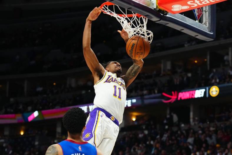 Apr 10, 2022; Denver, Colorado, USA; Los Angeles Lakers guard Malik Monk (11) finishes off a basket in the second half against the Denver Nuggets at Ball Arena. Mandatory Credit: Ron Chenoy-USA TODAY Sports