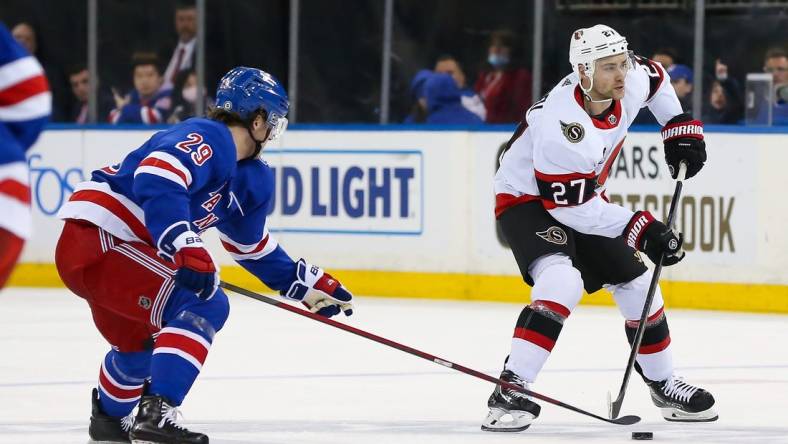 Apr 9, 2022; New York, New York, USA; Ottawa Senators center Dylan Gambrell (27) moves the puck past New York Rangers left wing Dryden Hunt (29) during the third period at Madison Square Garden. Mandatory Credit: Tom Horak-USA TODAY Sports