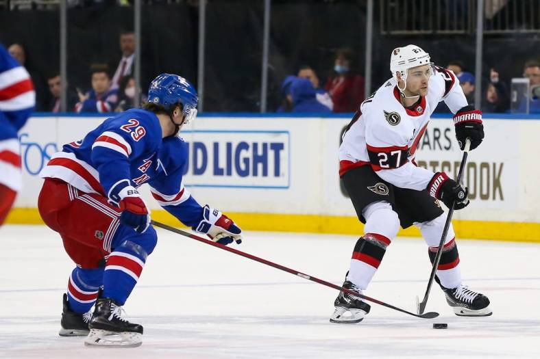 Apr 9, 2022; New York, New York, USA; Ottawa Senators center Dylan Gambrell (27) moves the puck past New York Rangers left wing Dryden Hunt (29) during the third period at Madison Square Garden. Mandatory Credit: Tom Horak-USA TODAY Sports