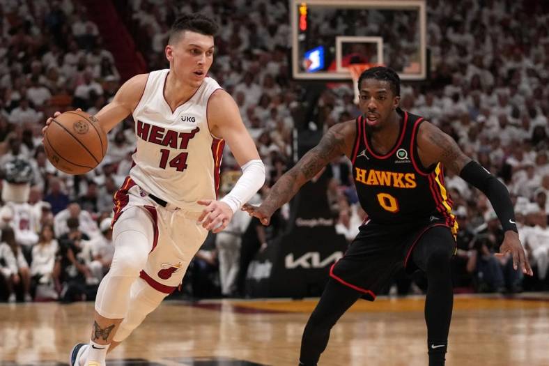 Apr 19, 2022; Miami, Florida, USA; Miami Heat guard Tyler Herro (14) drives the ball around Atlanta Hawks guard Delon Wright (0) during the first half in game two of the first round for the 2022 NBA playoffs at FTX Arena. Mandatory Credit: Jasen Vinlove-USA TODAY Sports