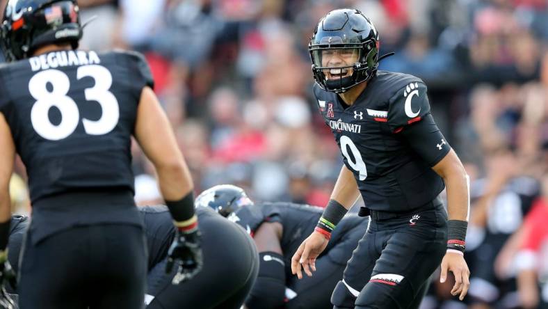 Cincinnati Bearcats quarterback Desmond Ridder (9) instructs Cincinnati Bearcats tight end Josiah Deguara (83) in the first quarter of an NCAA football game against the UCLA Bruins, Thursday, Aug. 29, 2019, at Nippert Stadium in Cincinnati.Ucla Bruins At Cincinnati Bearcats Aug 29