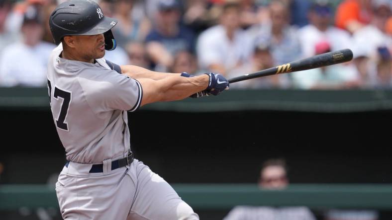 May 19, 2022; Baltimore, Maryland, USA; New York Yankees designated hitter Giancarlo Stanton (27) drives in two runs in the first inning against the Baltimore Orioles at Oriole Park at Camden Yards. Mandatory Credit: Mitch Stringer-USA TODAY Sports