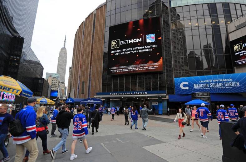 May 24, 2022; New York, New York, USA; The Empire State Building is seen in the distance as New York Rangers fans walk into Madison Square Garden before game four of the second round of the 2022 Stanley Cup Playoffs between the Rangers and Carolina Hurricanes at Madison Square Garden. Mandatory Credit: Danny Wild-USA TODAY Sports