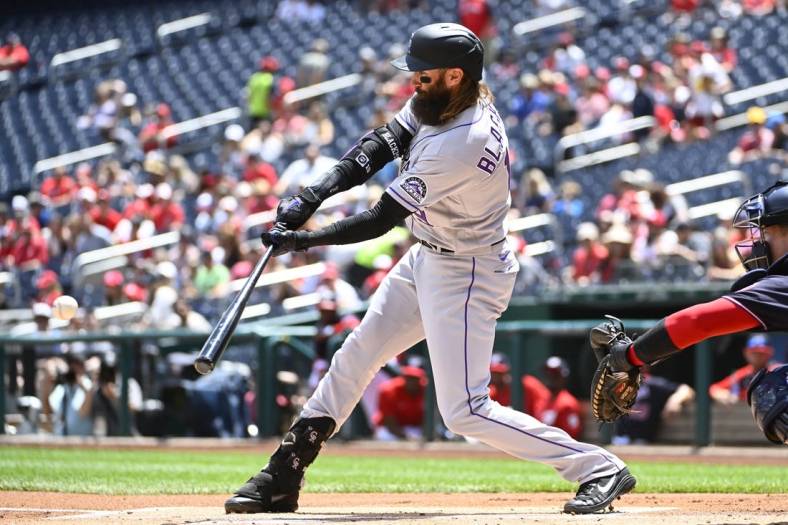 May 28, 2022; Washington, District of Columbia, USA; Colorado Rockies right fielder Charlie Blackmon (19) hits a single against the Washington Nationals during the first inning at Nationals Park. Mandatory Credit: Brad Mills-USA TODAY Sports