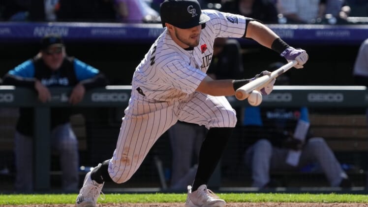May 30, 2022; Denver, Colorado, USA; Colorado Rockies shortstop Garrett Hampson (1) singles on a bunt in the seventh inning against the Miami Marlins at Coors Field. Mandatory Credit: Ron Chenoy-USA TODAY Sports