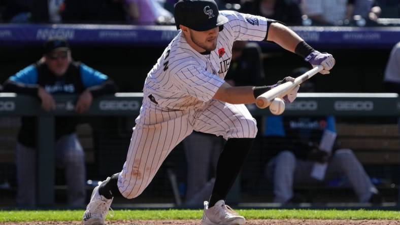 May 30, 2022; Denver, Colorado, USA; Colorado Rockies shortstop Garrett Hampson (1) singles on a bunt in the seventh inning against the Miami Marlins at Coors Field. Mandatory Credit: Ron Chenoy-USA TODAY Sports