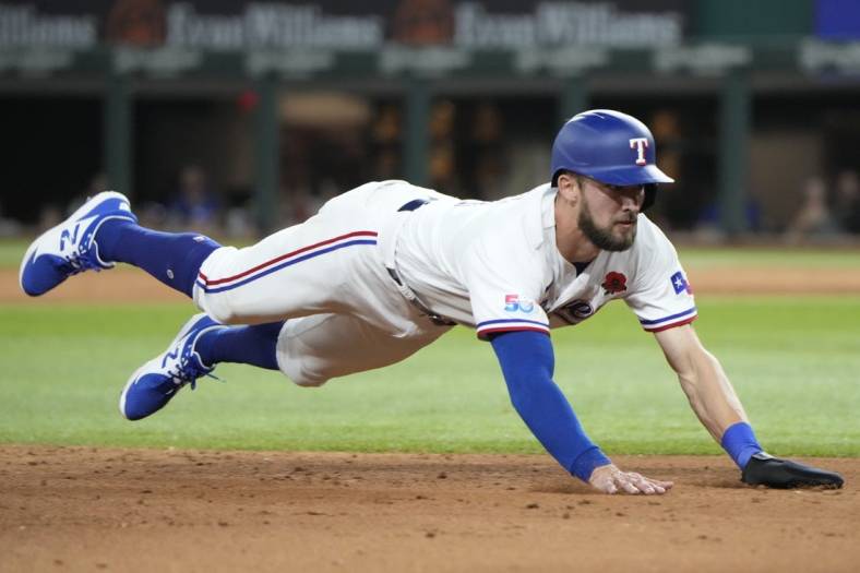 May 30, 2022; Arlington, Texas, USA; Texas Rangers center fielder Eli White (41) dives to third on a fly-out hit by shortstop Corey Seager (not pictured) against the Tampa Bay Rays during the sixth inning at Globe Life Field. Mandatory Credit: Jim Cowsert-USA TODAY Sports