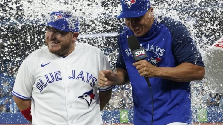 May 31, 2022; Toronto, Ontario, CAN; Toronto Blue Jays designated hitter Alejandro Kirk (left) and interpreter Hector Lebron (right) gets doused with water after a win over the Chicago White Sox at Rogers Centre. Mandatory Credit: John E. Sokolowski-USA TODAY Sports