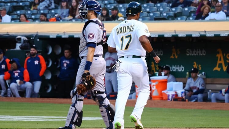 May 31, 2022; Oakland, California, USA; Oakland Athletics shortstop Elvis Andrus (17) scores a run behind Houston Astros catcher Jason Castro (18) during the fourth inning at RingCentral Coliseum. Mandatory Credit: Kelley L Cox-USA TODAY Sports