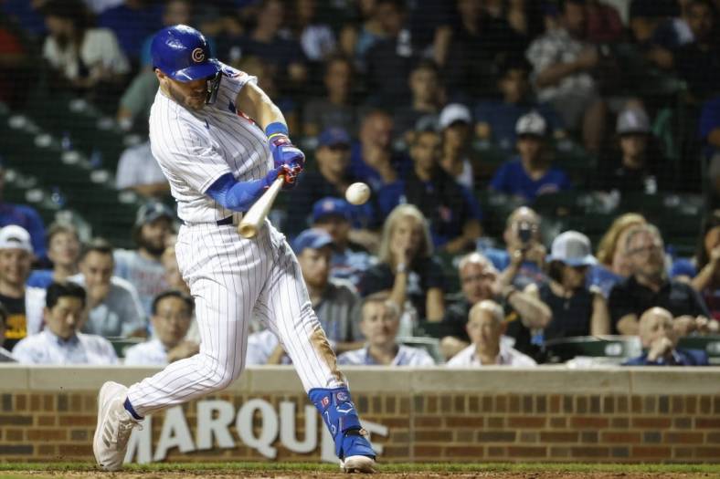May 31, 2022; Chicago, Illinois, USA; Chicago Cubs third baseman Patrick Wisdom (16) hits a solo home run against the Milwaukee Brewers during the eight inning at Wrigley Field. Mandatory Credit: Kamil Krzaczynski-USA TODAY Sports