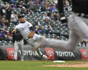 Jun 1, 2022; Denver, Colorado, USA; Colorado Rockies second baseman Ryan McMahon (left) attempts to throw out Miami Marlins third baseman Luke Williams (right) after a bunt during the second inning at Coors Field. Mandatory Credit: John Leyba-USA TODAY Sports