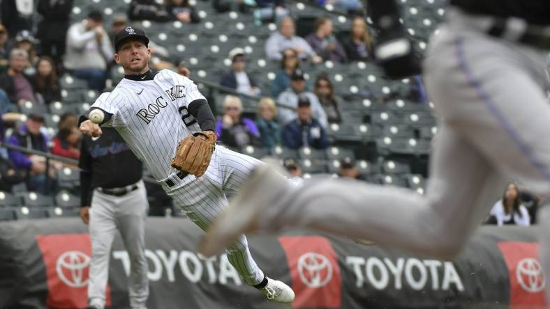 Jun 1, 2022; Denver, Colorado, USA; Colorado Rockies second baseman Ryan McMahon (left) attempts to throw out Miami Marlins third baseman Luke Williams (right) after a bunt during the second inning at Coors Field. Mandatory Credit: John Leyba-USA TODAY Sports