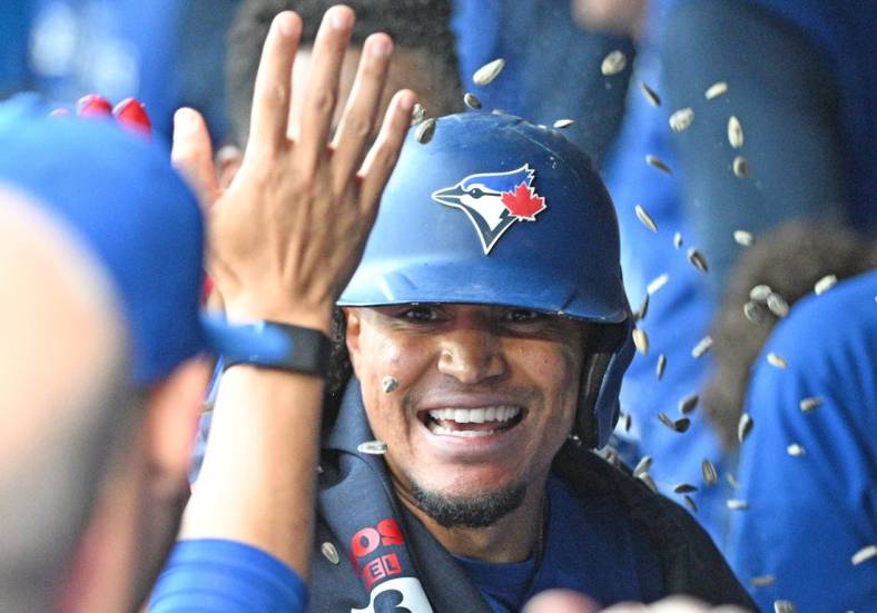 Jun 1, 2022; Toronto, Ontario, CAN; Toronto Blue Jays second baseman Santiago Espinal (5) is greeted by team mates in the dugout after hitting a solo home run against the Chicago White Sox in the first inning at Rogers Centre. Mandatory Credit: Dan Hamilton-USA TODAY Sports
