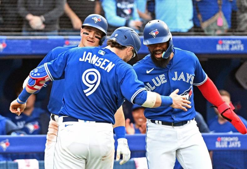 Jun 1, 2022; Toronto, Ontario, CAN; Toronto Blue Jays catcher Danny Jansen (9) is greeted at home plate by right fielder Teoscar Hernandez (right) and third baseman Matt Chapman (26) after hitting a three run home run against the Chicago White Sox in the third inning at Rogers Centre. Mandatory Credit: Dan Hamilton-USA TODAY Sports