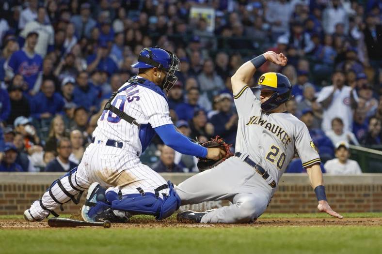Jun 1, 2022; Chicago, Illinois, USA; Milwaukee Brewers second baseman Mike Brosseau (20) scores against Chicago Cubs catcher Willson Contreras (40) during the fifth inning at Wrigley Field. Mandatory Credit: Kamil Krzaczynski-USA TODAY Sports