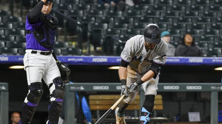Jun 1, 2022; Denver, Colorado, USA; Colorado Rockies catcher Brian Serven (6) looks on as Miami Marlins third baseman Jon Berti (5) slams his bat on the ground and breaking it after flying out during the ninth inning at Coors Field. Mandatory Credit: John Leyba-USA TODAY Sports