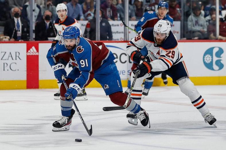 Jun 2, 2022; Denver, Colorado, USA; Colorado Avalanche center Nazem Kadri (91) controls the puck under pressure from Edmonton Oilers center Leon Draisaitl (29) in the second period in game two of the Western Conference Final of the 2022 Stanley Cup Playoffs at Ball Arena. Mandatory Credit: Isaiah J. Downing-USA TODAY Sports