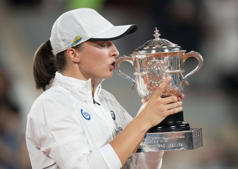 June 4, 2022; Paris, France; Iga Swiatek (POL) kisses the trophy after winning the women's singles final against Coco Gauff (USA) on day 14 of the French Open at Stade Roland-Garros. Mandatory Credit: Susan Mullane-USA TODAY Sports