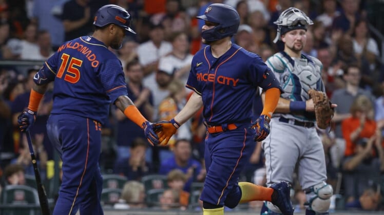 Jun 6, 2022; Houston, Texas, USA; Houston Astros center fielder Chas McCormick (20) celebrates with catcher Martin Maldonado (15) as Seattle Mariners catcher Cal Raleigh (29) looks on during the second inning at Minute Maid Park. Mandatory Credit: Troy Taormina-USA TODAY Sports