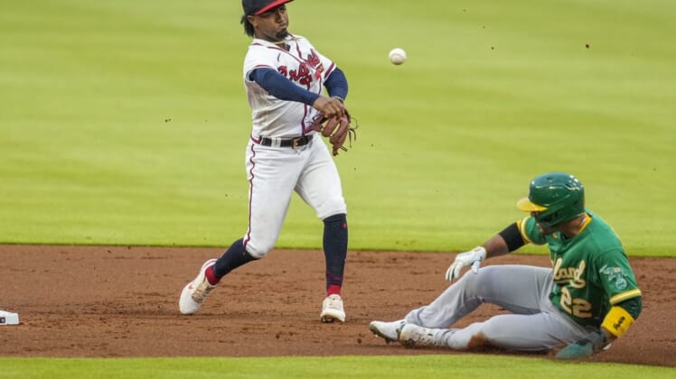 Jun 7, 2022; Cumberland, Georgia, USA; Atlanta Braves second baseman Ozzie Albies (1) throws for a double play over top of  Oakland Athletics right fielder Ramon Laureano (22) during the first inning at Truist Park. Mandatory Credit: Dale Zanine-USA TODAY Sports