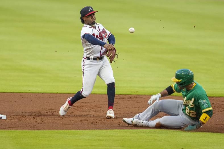 Jun 7, 2022; Cumberland, Georgia, USA; Atlanta Braves second baseman Ozzie Albies (1) throws for a double play over top of  Oakland Athletics right fielder Ramon Laureano (22) during the first inning at Truist Park. Mandatory Credit: Dale Zanine-USA TODAY Sports