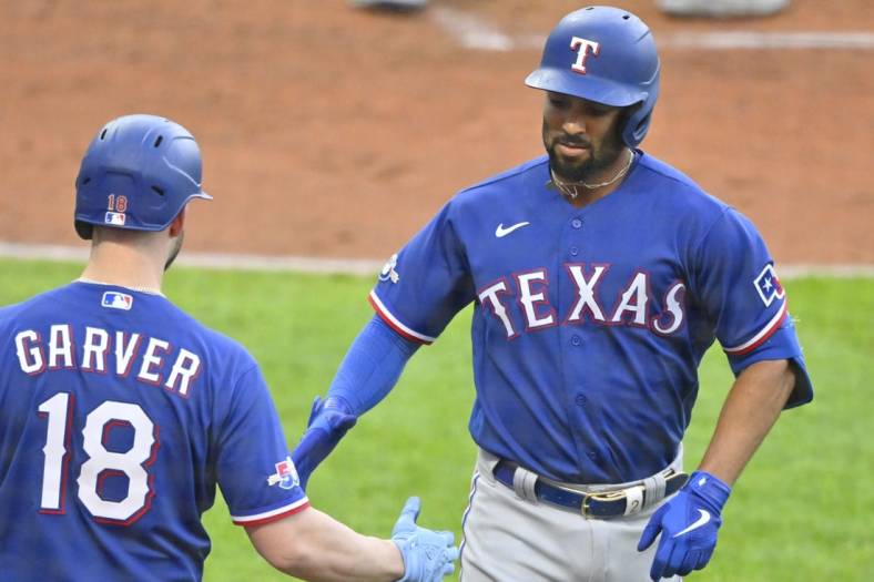 Jun 7, 2022; Cleveland, Ohio, USA; Texas Rangers second baseman Marcus Semien (2) celebrates his solo home run with designated hitter Mitch Garver (18) in the third inning against the Cleveland Guardians at Progressive Field. Mandatory Credit: David Richard-USA TODAY Sports