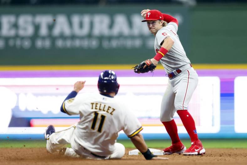 Jun 7, 2022; Milwaukee, Wisconsin, USA;  Philadelphia Phillies shortstop Bryson Stott (5) turns a double play as Milwaukee Brewers first baseman Rowdy Tellez (11) slides into second base during the seventh inning at American Family Field. Mandatory Credit: Jeff Hanisch-USA TODAY Sports
