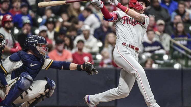 Jun 8, 2022; Milwaukee, Wisconsin, USA; Philadelphia Phillies second baseman Bryson Stott (5) hits a 2-run homer in the third inning as Milwaukee Brewers catcher Victor Caratini (7) watches at American Family Field. Mandatory Credit: Benny Sieu-USA TODAY Sports