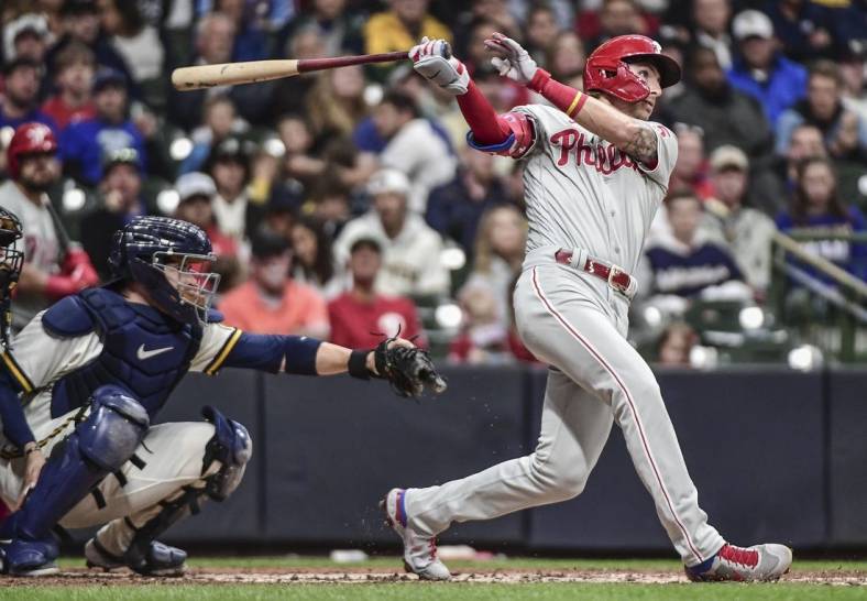 Jun 8, 2022; Milwaukee, Wisconsin, USA; Philadelphia Phillies second baseman Bryson Stott (5) hits a 2-run homer in the third inning as Milwaukee Brewers catcher Victor Caratini (7) watches at American Family Field. Mandatory Credit: Benny Sieu-USA TODAY Sports