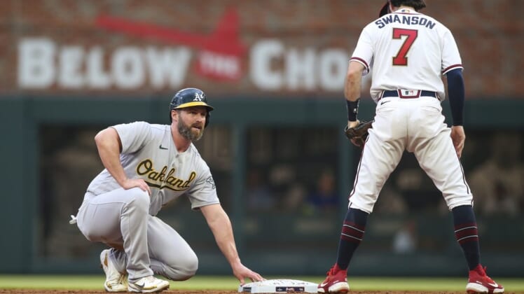 Jun 8, 2022; Atlanta, Georgia, USA; Oakland Athletics first baseman Matt Davidson (4) reacts after being called out on a stolen base attempt as Atlanta Braves shortstop Dansby Swanson (7) looks on in the third inning at Truist Park. Mandatory Credit: Brett Davis-USA TODAY Sports