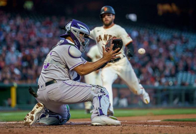 Jun 8, 2022; San Francisco, California, USA;  Colorado Rockies catcher Elias Diaz (35) fields the throw and tags out San Francisco Giants right fielder Luis Gonzalez (51) at home plate at Oracle Park. Mandatory Credit: Neville E. Guard-USA TODAY Sports