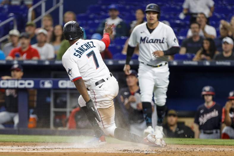 Jun 9, 2022; Miami, Florida, USA; Miami Marlins center fielder Jesus Sanchez (7) scores a run after a two-run RBI double hit by third baseman Jon Berti (not pictured) during the first inning against the Washington Nationals at loanDepot Park. Mandatory Credit: Sam Navarro-USA TODAY Sports