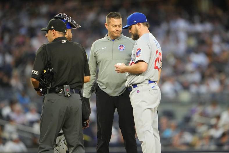 Jun 10, 2022; Bronx, New York, USA; The Chicago Cubs trainer P.J. Mainville attends to pitcher Wade Miley (20) during the fourth inning against the New York Yankees at Yankee Stadium. Mandatory Credit: Gregory Fisher-USA TODAY Sports