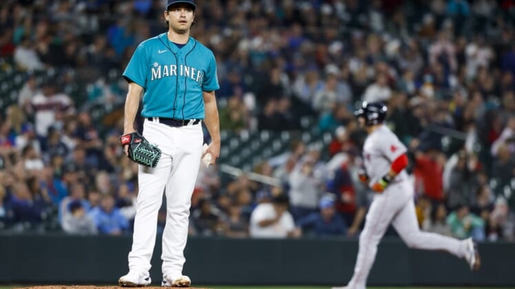 Jun 10, 2022; Seattle, Washington, USA; Seattle Mariners starting pitcher Marco Gonzales (7) stands on the mound after surrendering a solo-home run to Boston Red Sox designated hitter J.D. Martinez (28, background) during the third inning at T-Mobile Park. Mandatory Credit: Joe Nicholson-USA TODAY Sports