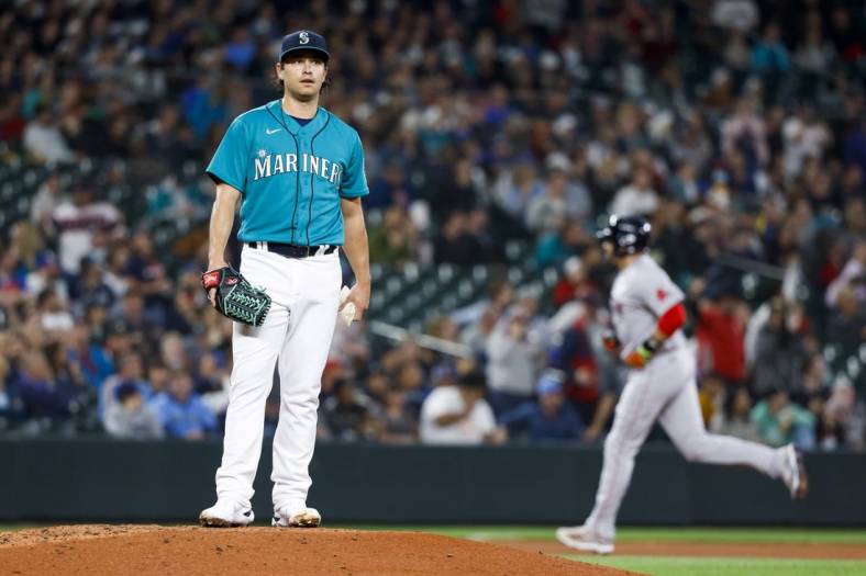 Jun 10, 2022; Seattle, Washington, USA; Seattle Mariners starting pitcher Marco Gonzales (7) stands on the mound after surrendering a solo-home run to Boston Red Sox designated hitter J.D. Martinez (28, background) during the third inning at T-Mobile Park. Mandatory Credit: Joe Nicholson-USA TODAY Sports