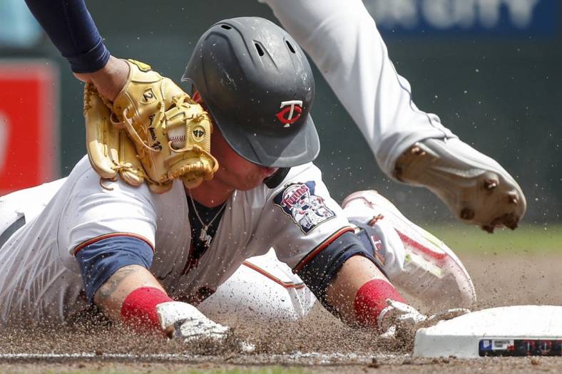 Jun 11, 2022; Minneapolis, Minnesota, USA; Tampa Bay Rays third baseman Yandy Diaz (2) tags out Minnesota Twins third baseman Jose Miranda (64) on his RBI double which he tried to stretch into a triple in the third inning at Target Field. Mandatory Credit: Bruce Kluckhohn-USA TODAY Sports