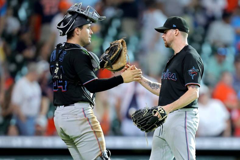 Jun 11, 2022; Houston, Texas, USA; Miami Marlina catcher Nick Fortes (54, left) shakes hands with relief pitcher Louis Head (38, right) after the final out against the Houston Astros during the ninth inning at Minute Maid Park. Mandatory Credit: Erik Williams-USA TODAY Sports
