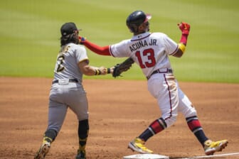 Jun 12, 2022; Cumberland, Georgia, USA; Atlanta Braves right fielder Ronald Acuna Jr. (13) gets back to first base ahead of the tag by Pittsburgh Pirates first baseman Michael Chavis (2) during the first inning at Truist Park. Mandatory Credit: Dale Zanine-USA TODAY Sports