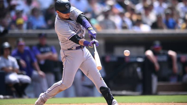 Jun 12, 2022; San Diego, California, USA; Colorado Rockies shortstop Jose Iglesias (11) hits a single during the eighth inning against the San Diego Padres at Petco Park. Mandatory Credit: Orlando Ramirez-USA TODAY Sports