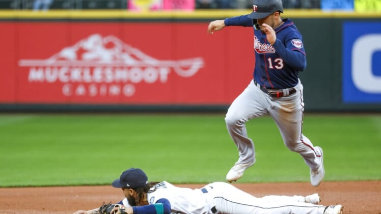 Jun 13, 2022; Seattle, Washington, USA; Minnesota Twins left fielder Trevor Larnach (13) jumps over Seattle Mariners shortstop J.P. Crawford (3) to advance to third base on a hit by a teammate during the second inning at T-Mobile Park. Mandatory Credit: Joe Nicholson-USA TODAY Sports