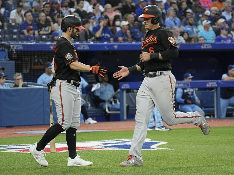 Jun 14, 2022; Toronto, Ontario, CAN; Baltimore Orioles first baseman Ryan Mountcastle (6) gets congratulated by left fielder Ryan McKenna (26) after scoring against the Toronto Blue Jays during the fifth inning at Rogers Centre. Mandatory Credit: John E. Sokolowski-USA TODAY Sports
