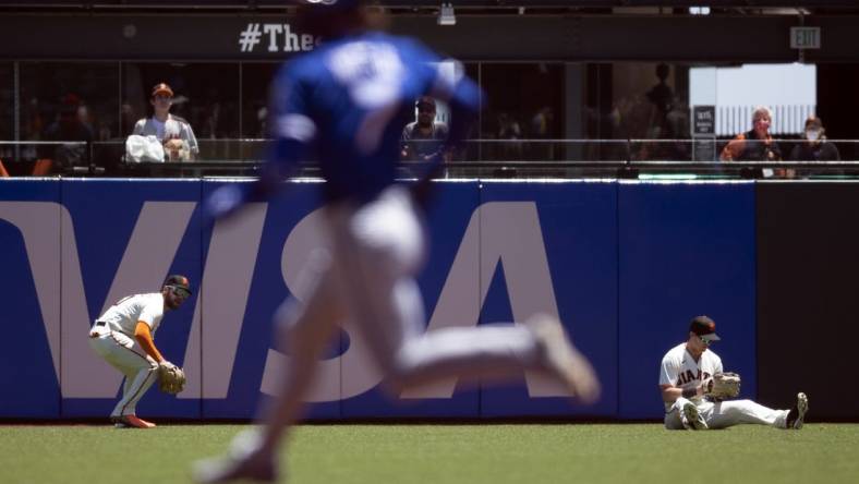 Jun 15, 2022; San Francisco, California, USA; San Francisco Giants right fielder Luis Gonzalez (51) retrieves a double hit by Kansas City Royals shortstop Bobby Witt Jr. (7) after center fielder Mike Yastrzemski (5) lost his footing in the first inning at Oracle Park. Mandatory Credit: D. Ross Cameron-USA TODAY Sports