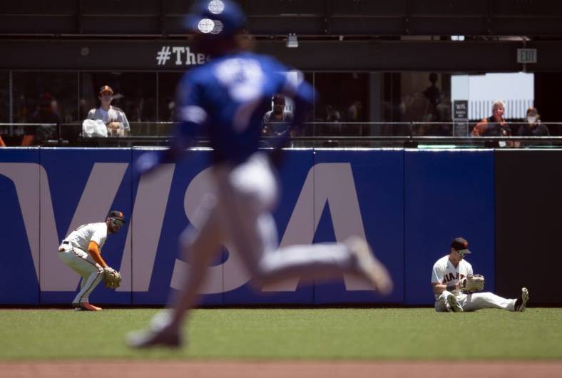 Jun 15, 2022; San Francisco, California, USA; San Francisco Giants right fielder Luis Gonzalez (51) retrieves a double hit by Kansas City Royals shortstop Bobby Witt Jr. (7) after center fielder Mike Yastrzemski (5) lost his footing in the first inning at Oracle Park. Mandatory Credit: D. Ross Cameron-USA TODAY Sports