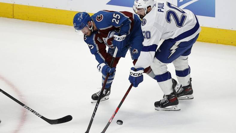 Jun 15, 2022; Denver, Colorado, USA; Colorado Avalanche right wing Logan O'Connor (25) and Tampa Bay Lightning left wing Nicholas Paul (20) battle for the puck during the first period of game one of the 2022 Stanley Cup Final at Ball Arena. Lightning. Mandatory Credit: Isaiah J. Downing-USA TODAY Sports