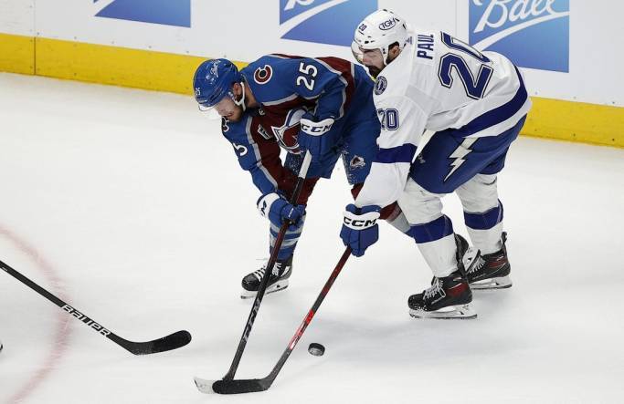 Jun 15, 2022; Denver, Colorado, USA; Colorado Avalanche right wing Logan O'Connor (25) and Tampa Bay Lightning left wing Nicholas Paul (20) battle for the puck during the first period of game one of the 2022 Stanley Cup Final at Ball Arena. Lightning. Mandatory Credit: Isaiah J. Downing-USA TODAY Sports