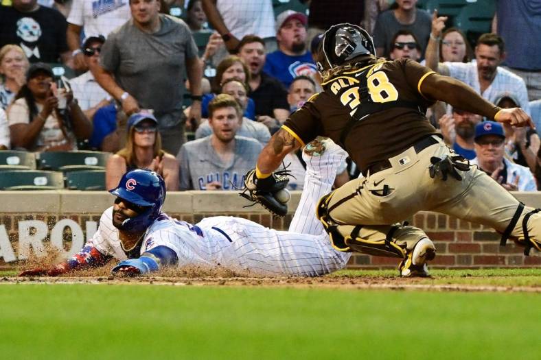 Jun 15, 2022; Chicago, Illinois, USA; Chicago Cubs second baseman Jonathan Villar (24) beats the tag from San Diego Padres catcher Jorge Alfaro (38) to score in the second inning at Wrigley Field. Mandatory Credit: Quinn Harris-USA TODAY Sports