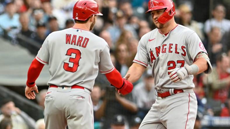 Jun 16, 2022; Seattle, Washington, USA; Los Angeles Angels center fielder Mike Trout (27) and right fielder Taylor Ward (3) celebrate at home plate after Trout hit a two-run home run against the Seattle Mariners during the third inning at T-Mobile Park. Mandatory Credit: Steven Bisig-USA TODAY Sports