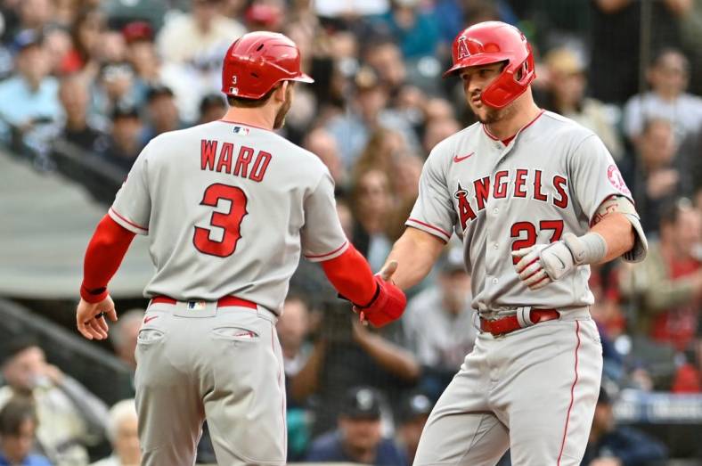 Jun 16, 2022; Seattle, Washington, USA; Los Angeles Angels center fielder Mike Trout (27) and right fielder Taylor Ward (3) celebrate at home plate after Trout hit a two-run home run against the Seattle Mariners during the third inning at T-Mobile Park. Mandatory Credit: Steven Bisig-USA TODAY Sports