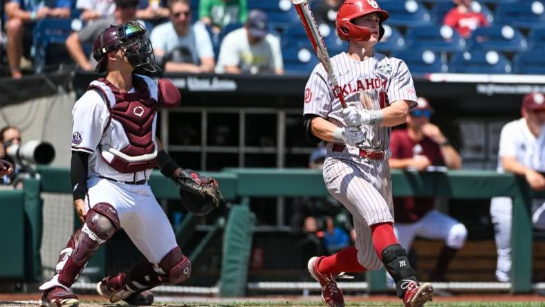 Jun 17, 2022; Omaha, NE, USA; Oklahoma Sooners second baseman Jackson Nicklaus (15) hits a grand slam home run against the Texas A&M Aggies in the fourth inning at Charles Schwab Field. Mandatory Credit: Steven Branscombe-USA TODAY Sports